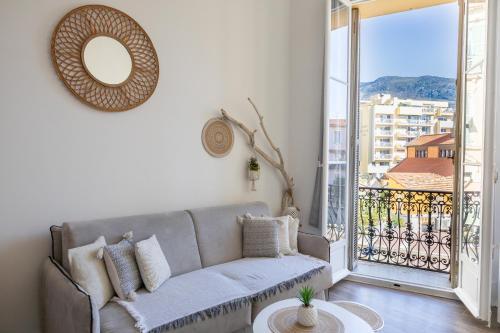 een woonkamer met een bank en een groot raam bij Le St Roch 2 in Menton