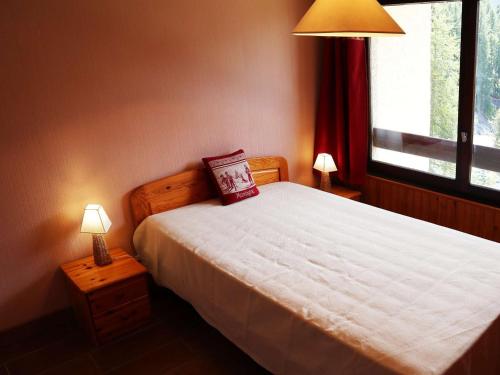 une chambre avec un lit avec deux lampes et une fenêtre dans l'établissement Appartement rénové 6 pers, au pied des pistes - FR-1-322-159, aux Orres