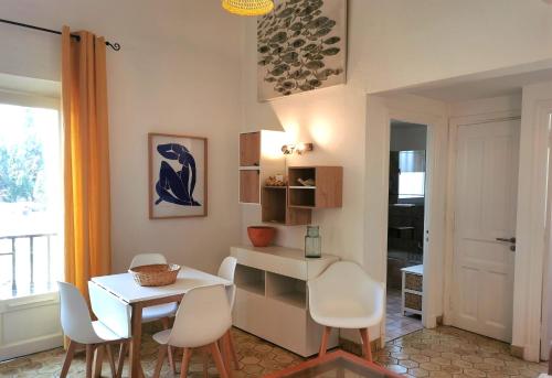 une salle à manger avec une table et des chaises blanches dans l'établissement Appartement 4 en duplex - LES SUITES DE ROBINSON - Résidence avec piscine en bord de Siagne, à Mandelieu-La-Napoule, à Mandelieu-la-Napoule