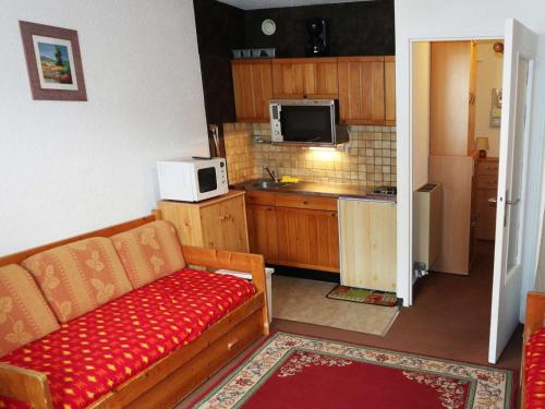 un salon avec un canapé et une cuisine dans l'établissement Studio cosy pour 4 pers. au pied des pistes - FR-1-322-292, aux Orres