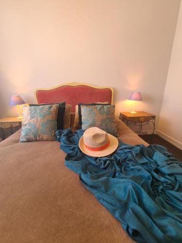 un chapeau assis au-dessus d'un lit dans l'établissement La Casa Sylvia, 6 pers WIFI, à Boulogne-sur-Mer