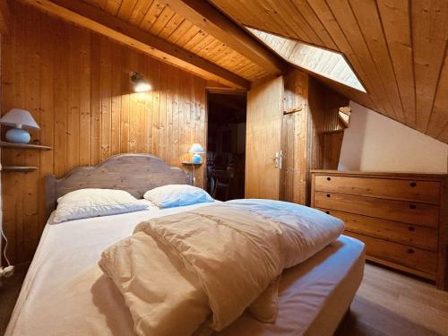 1 dormitorio con 1 cama grande y paredes de madera en Charmant T2 mezzanine 5 pers, balcon sud, proche centre et pistes, parking privé - Le Monêtier les Bains - FR-1-330F-158, en Le Monêtier-les-Bains