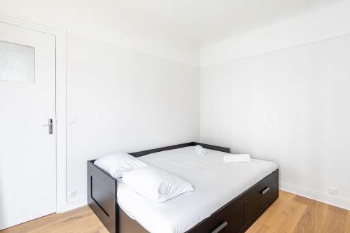 Cette petite chambre comprend un lit avec des draps blancs. dans l'établissement GuestReady - Sleek and Comfy Stay near the metro, à Paris