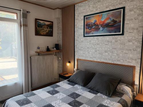 a bedroom with a bed and a brick wall at Le Clos des Passiflores in Pons