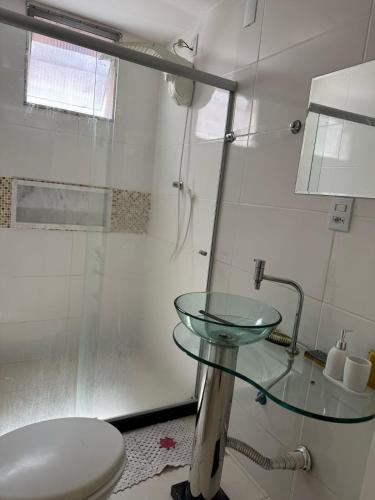 a bathroom with a glass sink and a toilet at Itapuã - 4 Minutos da Praia - Quarto com Suíte in Vila Velha
