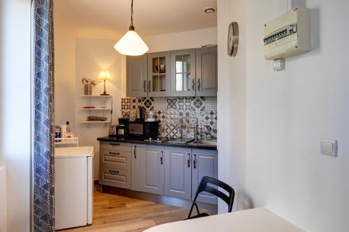 une cuisine avec des placards bleus et une table avec une chaise dans l'établissement Le Petit Longchamp, à Marseille