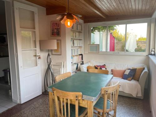 un salon avec une table et un canapé dans l'établissement La Maison de Marie à 5 minutes à pied de la Plage avec Parking privée et gratuit, à Lion-sur-Mer