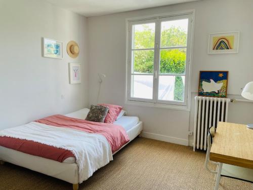 une chambre avec un lit et une fenêtre dans l'établissement La Maison de Marie à 5 minutes à pied de la Plage avec Parking privée et gratuit, à Lion-sur-Mer