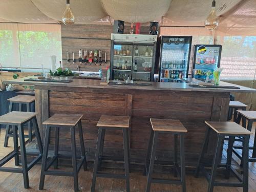 a bar with wooden stools and a counter at Gold Guest & Conference in Welkom