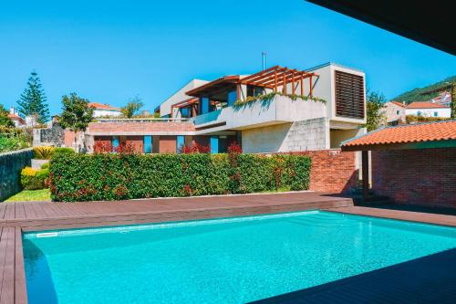 a house with a swimming pool in front of a house at Just Like Home - Casa do Caracol Horizon Retreat in Viana do Castelo
