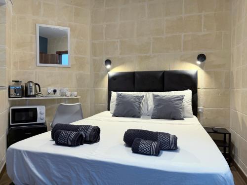 a bed with two pillows on it in a room at Mini Studios in Central Victoria in Victoria