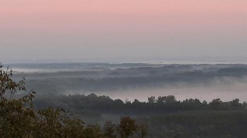 a foggy valley with trees in the distance at Eagle's View Villa in Batina