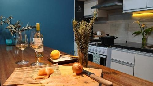a kitchen with a cutting board and a bottle of wine at Viraro Apart - Apto céntrico con estacionamiento in Salto