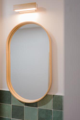 a round mirror on a wall in a bathroom at Apartamento Don Marcos B in Badajoz