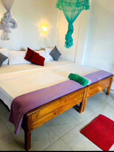 a bedroom with two beds and a bench at Ella viewpoint sunnyview in Ella