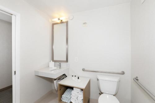 a bathroom with a toilet and a sink and a mirror at The Wayfarer San Diego in San Diego