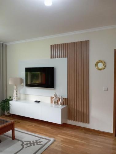 a living room with a tv on a white wall at Apartamento T2 Vila Nova Gaia in Vila Nova de Gaia