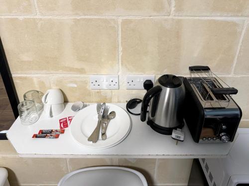a kitchen counter with a tea kettle and a sink at Mini Studios in Central Victoria in Victoria