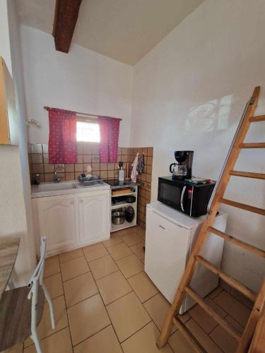 une petite cuisine avec une cuisinière et un micro-ondes dans l'établissement Studio Cosy, proche du port, tout se fait à pied, à Port-la-Nouvelle