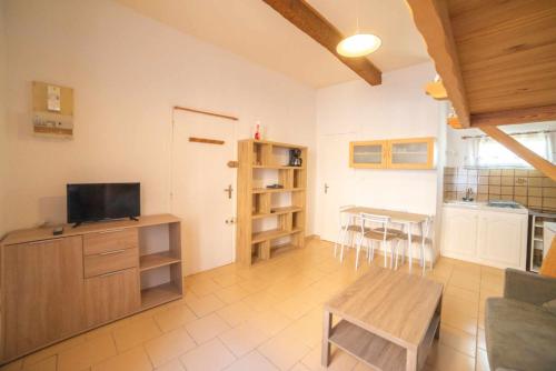 un salon avec une télévision et une table dans l'établissement Studio Cosy, proche du port, tout se fait à pied, à Port-la-Nouvelle