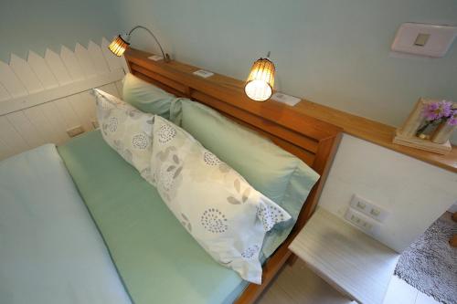 a bed with a wooden head board and a light at Huxi B&B in Jian