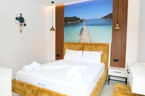 a bedroom with a bed with a picture of a pier at Vila La Familia in Ksamil