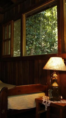 a lamp sitting on a table next to a window at Reserva Natural Don Rodolfo in Santa Ana