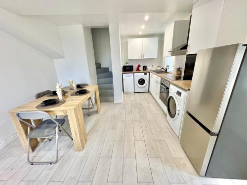 une cuisine avec une table en bois et un réfrigérateur dans l'établissement Maison 5 chambres, à Ocquerre
