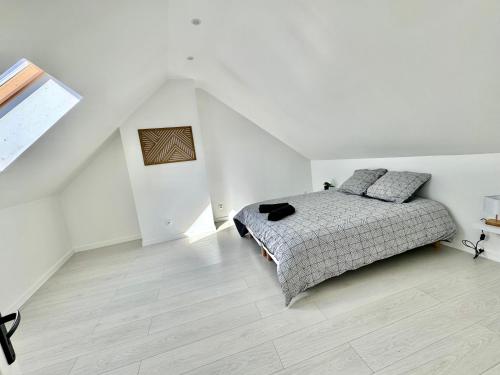 une chambre blanche avec un lit et un parquet dans l'établissement Maison 5 chambres, à Ocquerre