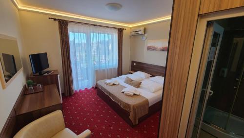 a hotel room with a bed and a window at Vila Cristal in Baile Felix