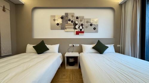 two beds sitting next to each other in a room at 禾夏民宿Her Shot Inn in Hengchun