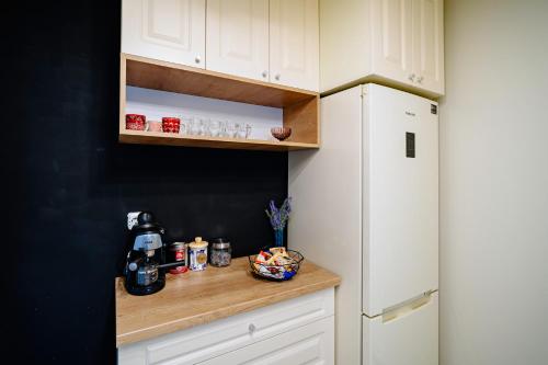 a kitchen with white cabinets and a white refrigerator at The QUARK Modern Designed 2BR Central Apartment in Craiova