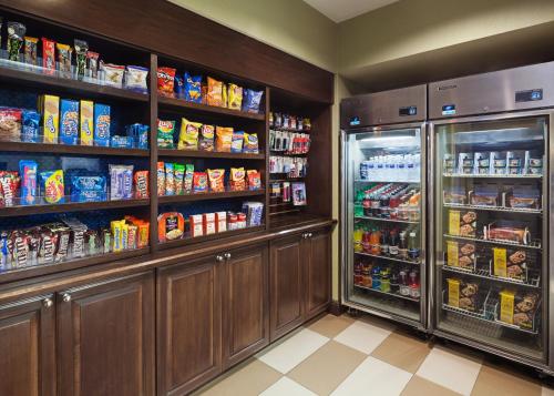 a kitchen with a refrigerator and lots of food at Hampton Inn & Suites Hobbs in Hobbs