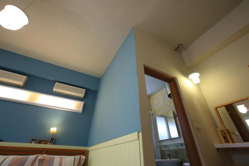 a room with a blue wall and a mirror at Huxi B&B in Jian