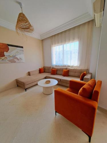 ein Wohnzimmer mit Sofa und Tisch in der Unterkunft Cosy 2 S prêt du carrefour in Sidi Daoud