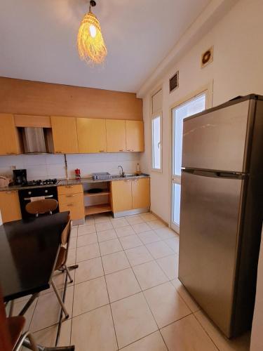 eine große Küche mit einem Kühlschrank aus Edelstahl in der Unterkunft Cosy 2 S prêt du carrefour in Sidi Daoud