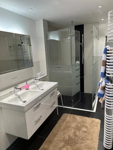 a white bathroom with a sink and a shower at Gasthof Landhotel Hirsch in Ostrach