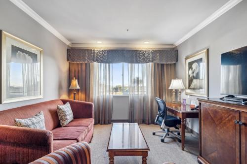 a living room with a couch and a desk at Villa Montes Hotel in San Bruno