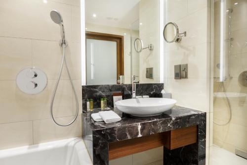 a bathroom with a sink and a shower at DoubleTree by Hilton Hotel & Conference Centre Warsaw in Warsaw