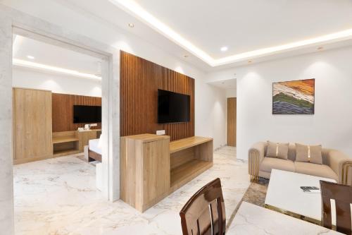 a living room with a tv and a couch and a table at White Wharf Beach Resort Morjim Goa in Morjim