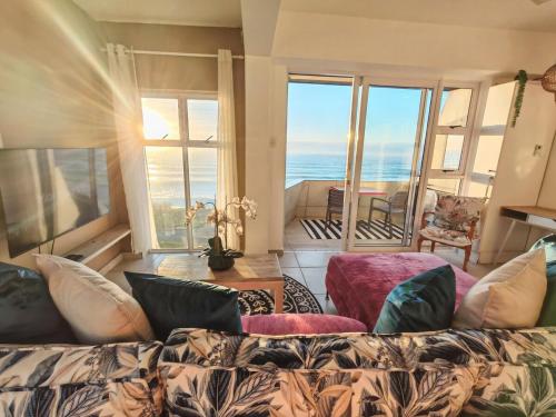 a living room with a couch and a view of the ocean at OCEAN SHOREBREAK - Umdloti resort - Back up Water in Umdloti