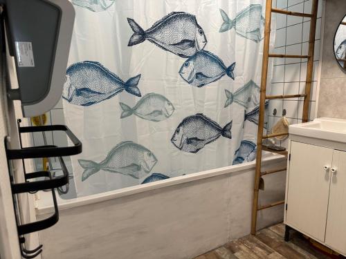 - un rideau de douche avec du poisson dans la salle de bains dans l'établissement Maison artistique atypique Atelihome, à Concarneau