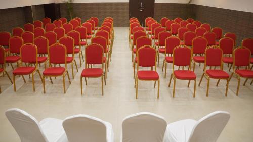 a row of chairs in a room with red chairs at Kani Residency Hotel in Tuticorin