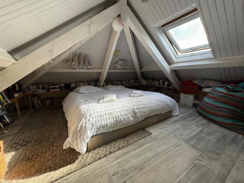 une chambre avec un lit dans un grenier dans l'établissement Maison artistique atypique Atelihome, à Concarneau