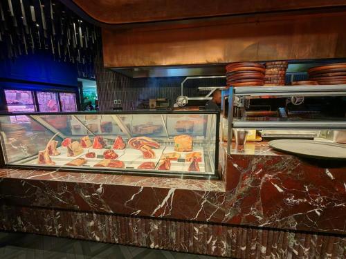 a display case in a restaurant with meats and cheese at OCEAN SHOREBREAK - Umdloti resort - Back up Water in Umdloti