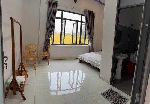 a bedroom with a bed and a large window at Hương Tràm Homestay in Hồ Ðá