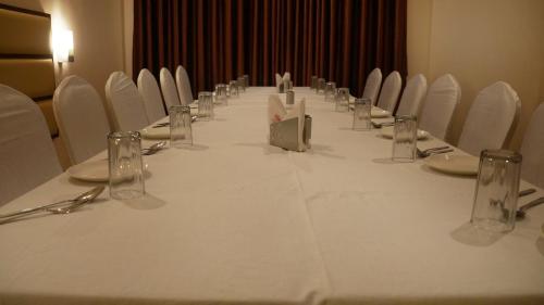 a long table with white chairs and a white table cloth at Kani Residency Hotel in Tuticorin