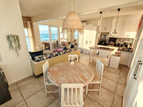 a kitchen and living room with a table and chairs at OCEAN SHOREBREAK - Umdloti resort - Back up Water in Umdloti