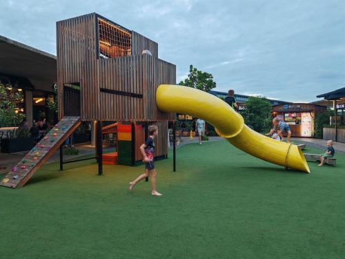 a child playing on a playground with a yellow slide at OCEAN SHOREBREAK - Umdloti resort - Back up Water in Umdloti