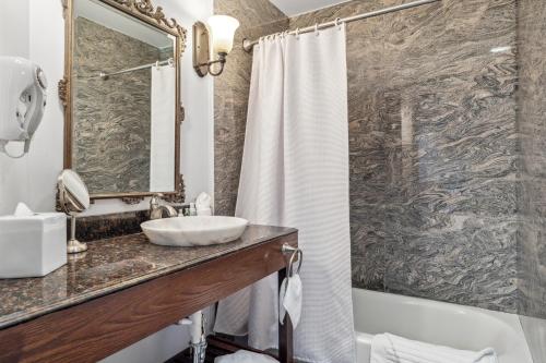 a bathroom with a sink and a shower at Villa Montes Hotel in San Bruno